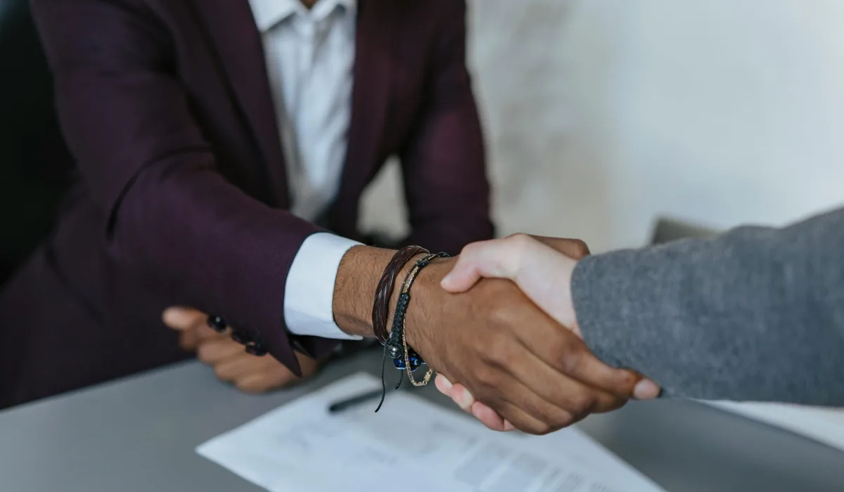 Two people shaking hands on a peer-to-peer lending agreement